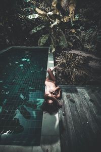 Woman relaxing by swimming pool