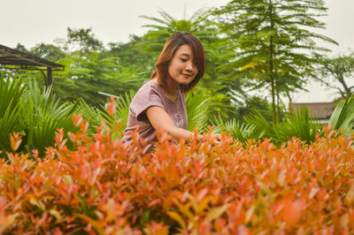 Young woman smiling while standing on field