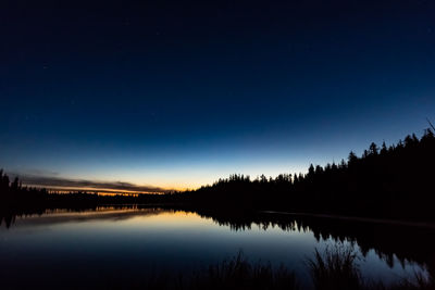 Scenic view of lake against sky at night