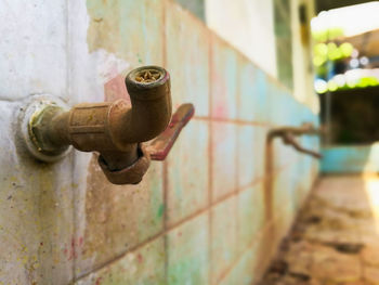 Close-up of human hand on rusty pipe