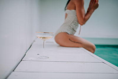 Midsection of woman holding glass of water