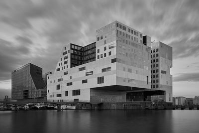 River by buildings against sky