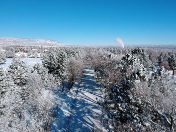 Snow covered landscape against clear blue sky