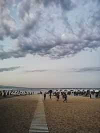 Group of people on beach against sky