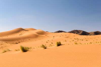 Scenic view of desert against clear blue sky