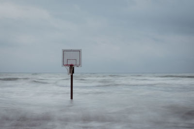 Basketball on beach against sky