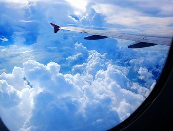 Aerial view of airplane wing against cloudy sky