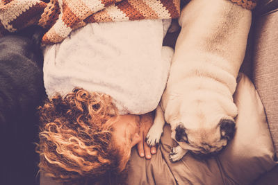 High angle view of woman with dogs sleeping on bed