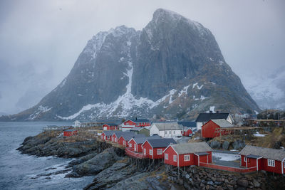 View of red houses next to the ocean in a norwegian fjord in lofoten