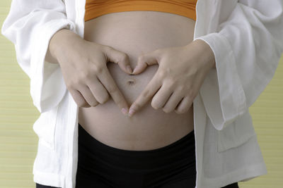 Midsection of woman touching mirror