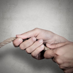 Close-up of man holding hands over white background