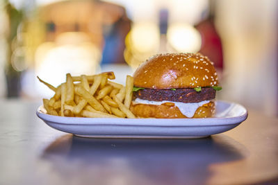 Close-up of burger and french fries in plate on table