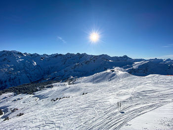 Scenic view of snowcapped mountains against blue sky