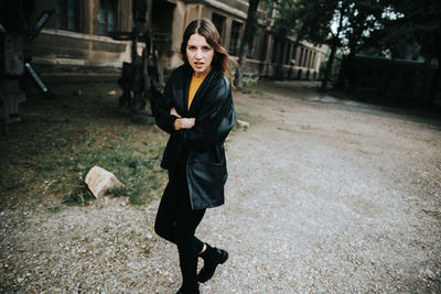 Full length portrait of young woman on walkway in city