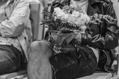 Portrait of young man sitting on potted plant
