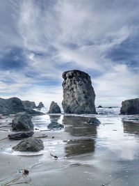 Rocks in sea against sky