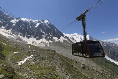 Overhead cable car on snowcapped mountains against sky