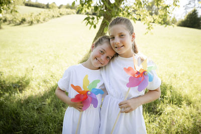 Portrait of smiling mother and daughter standing on field