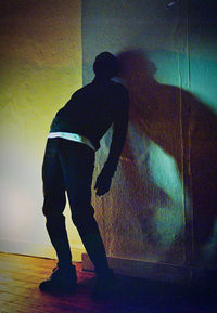 Silhouette woman standing against wall at home