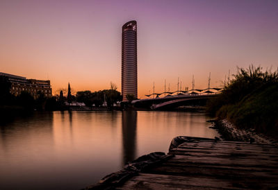 Bridge over river against sky during sunset