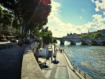 Bridge over river in city against sky