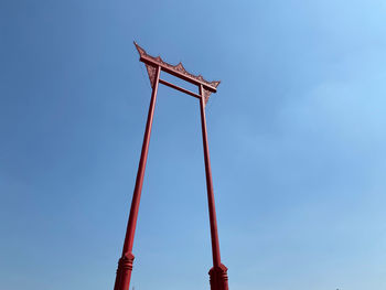 Low angle view of crane against clear blue sky