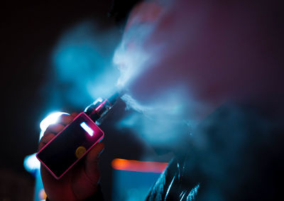 Close-up of hand on illuminated lighting equipment