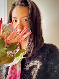 Close-up of asian woman with pink king protea flower.