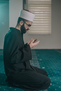 Side view of young man using mobile phone