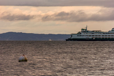 Boat sailing in sea against sky during sunset