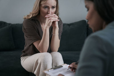 Scared woman listening to therapist at support center