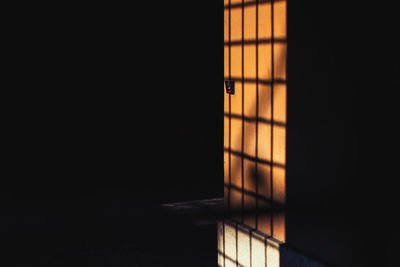 Illuminated building in darkroom