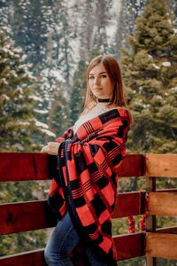 Portrait of young woman standing in forest