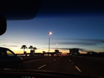 Cars on road against sky seen through car windshield