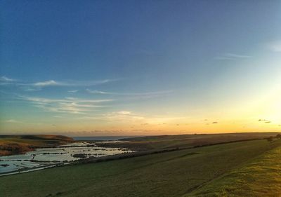 Scenic view of field against sky during sunset