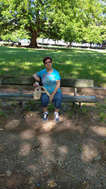 Portrait of man sitting on bench in park