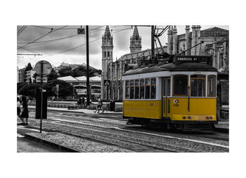 Train on railroad tracks in city against sky