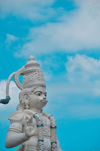 Low angle view of hanuman statue against blue sky