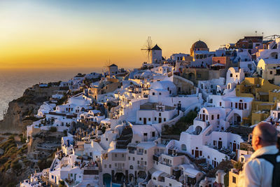 Man by houses at santorini during sunset