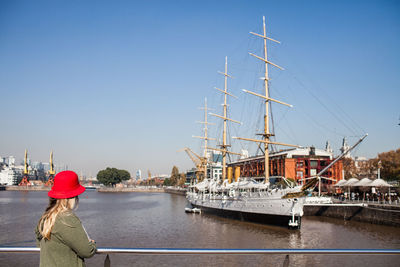 Woman standing on harbor against clear sky