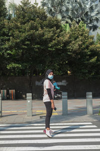 Full length side view of man walking on road