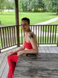 Portrait of young woman sitting at park