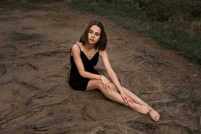 Full length of woman sitting on land