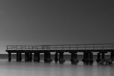 Bridge over sea against clear sky