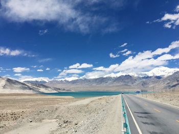 Panoramic view of road leading towards mountains against sky