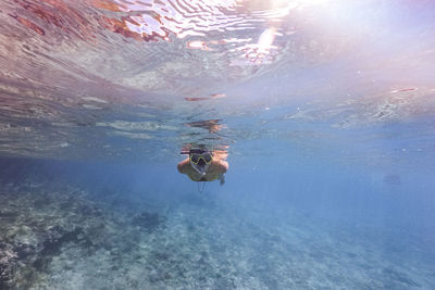 Young women coral reef scuba diving in sea ocean of curacao