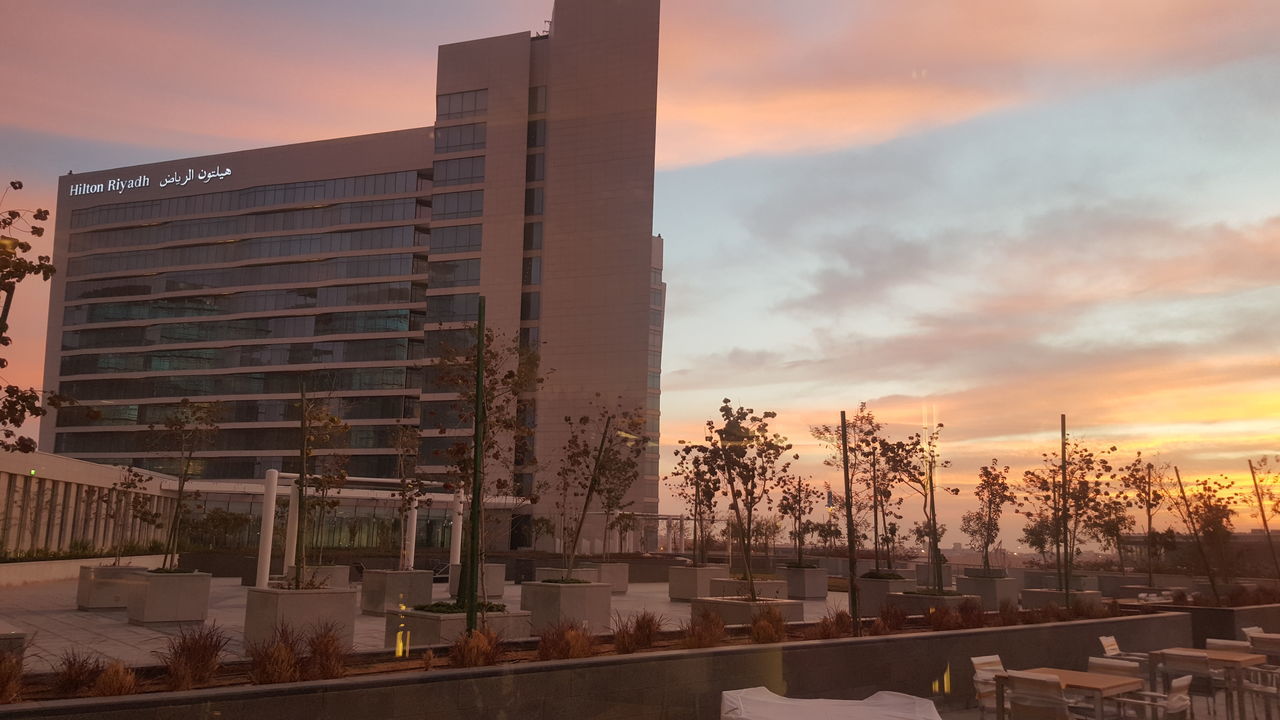 MODERN BUILDING AGAINST CLOUDY SKY