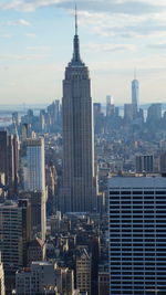 Modern buildings in city against cloudy sky