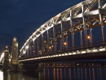 Illuminated bridge over river at night