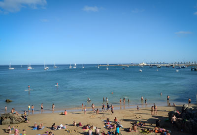 High angle view of people enjoying at sandy beach